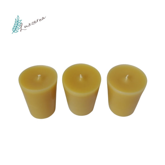 Three yellow candles on a white background with a brand logo in the corner.